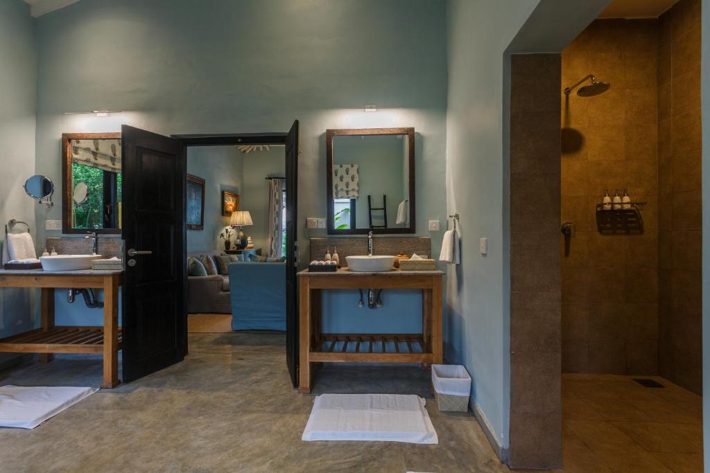 a bathroom with two sinks and a mirror at Kahanda Kanda in Koggala