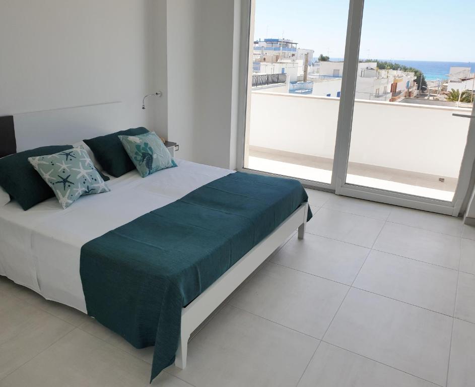 uma cama num quarto com uma grande janela em Appartamenti OltreMare em Gallipoli