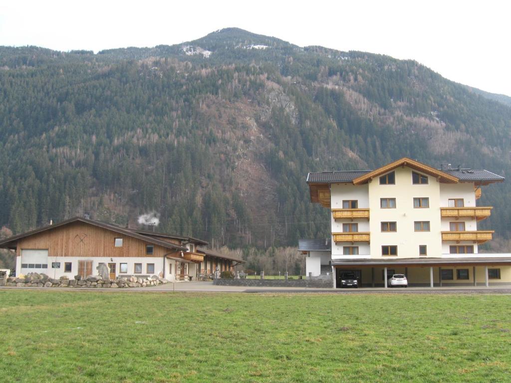 grupa budynków z górą w tle w obiekcie Apparthotel Stoanerhof w mieście Uderns