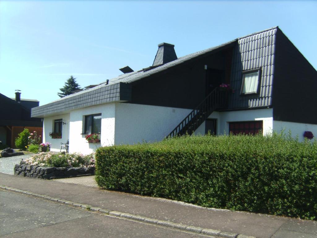 ein weißes Haus mit schwarzem Dach in der Unterkunft Ferienwohnung Evangeline Borsch in Zell an der Mosel