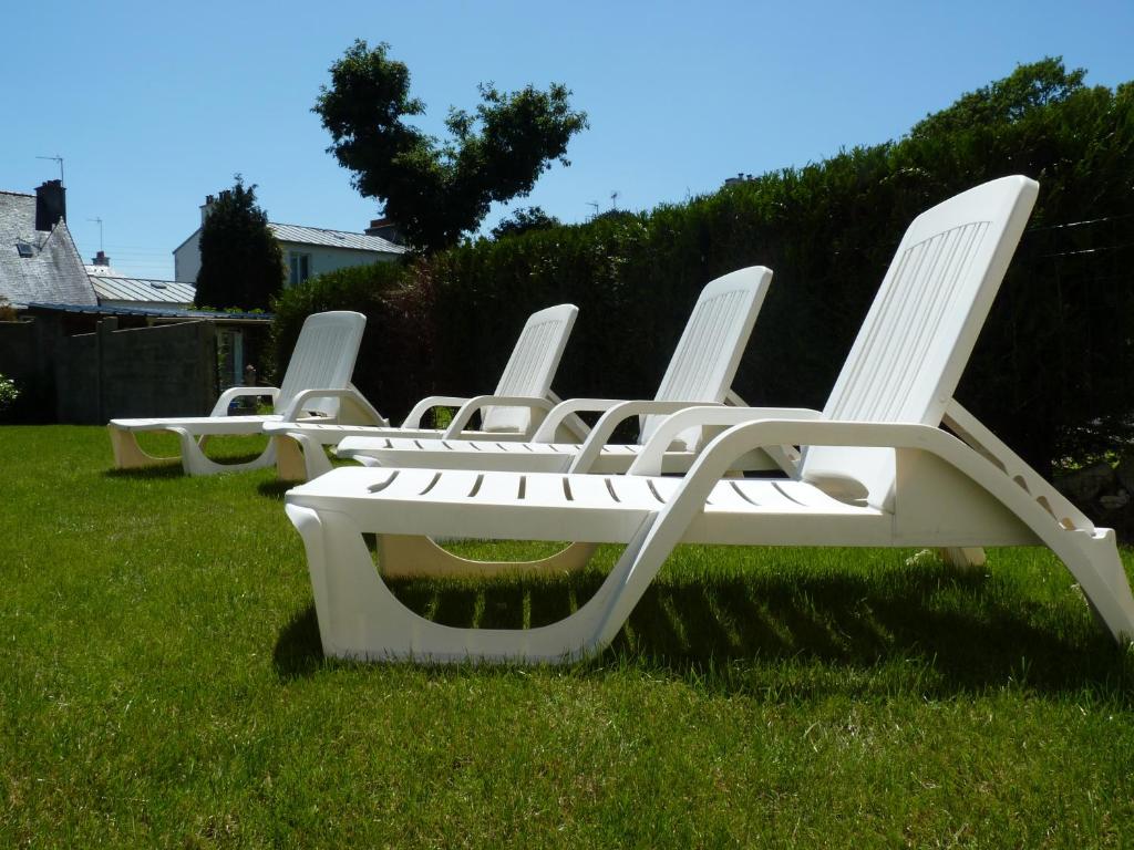 una fila de sillas blancas sentadas en el césped en Résidence Honoré de Balzac en Brest