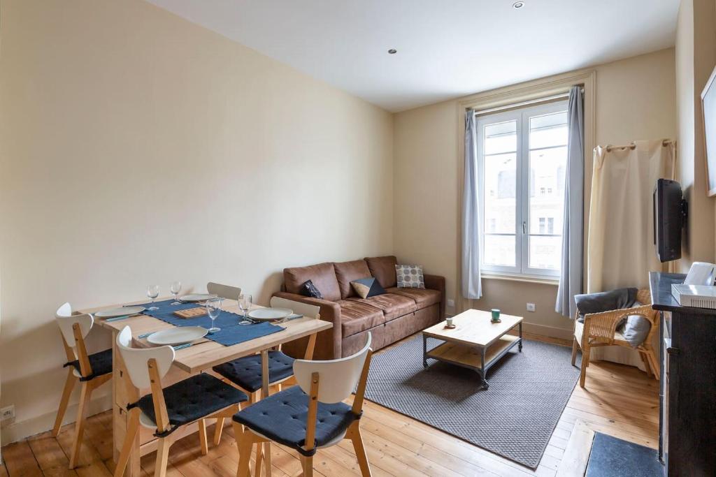 un salon avec une table et un canapé dans l'établissement Joli T3, gare & plages à proximité, à Saint-Malo