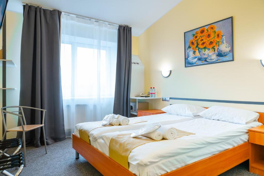 
a bedroom with a bed, a chair, and a window at Apart Hotel Tomo FREE PARKING in Rīga
