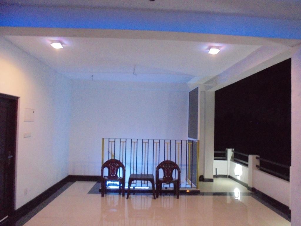 two chairs sitting in a living room with a television at JMF Hotel in Negombo