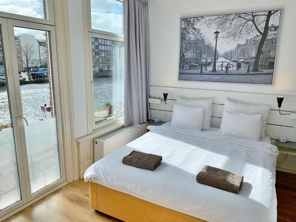 a bedroom with a white bed with two pillows on it at Jordaan View in Amsterdam