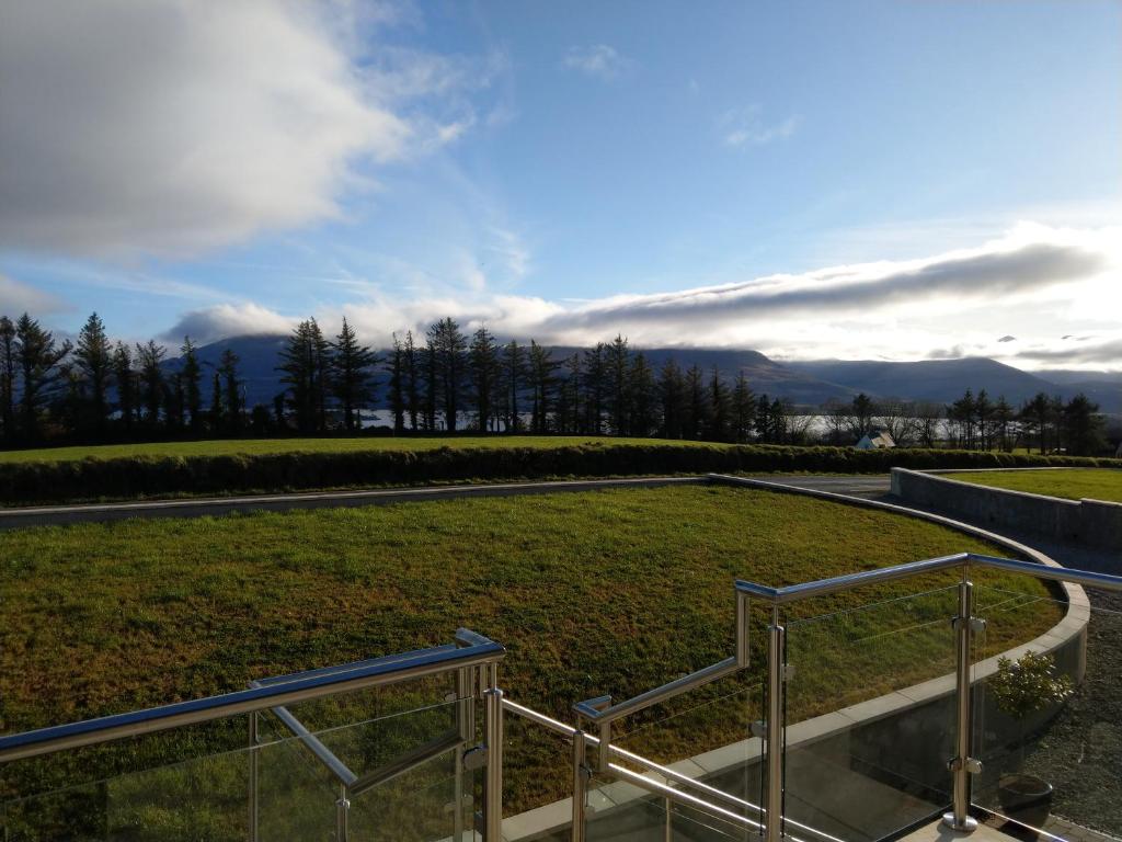 una escalera que conduce a un campo de césped con montañas en el fondo en Arbutus Lodge en Killarney