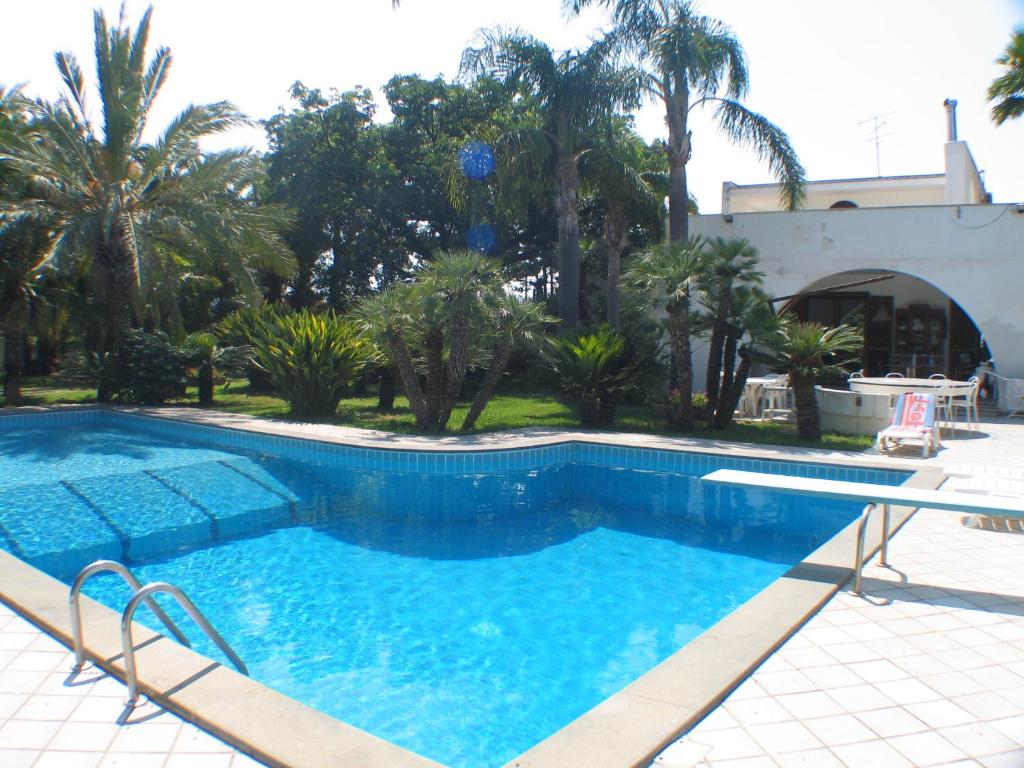 a swimming pool in a yard with palm trees at Cuore Di Palme in Floridia