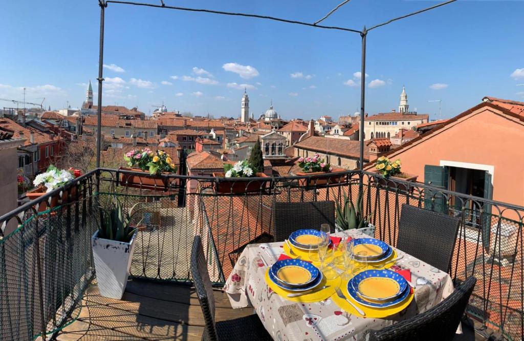 una mesa en un balcón con vistas a la ciudad en Casa Jaqueline ( Attico ), en Venecia