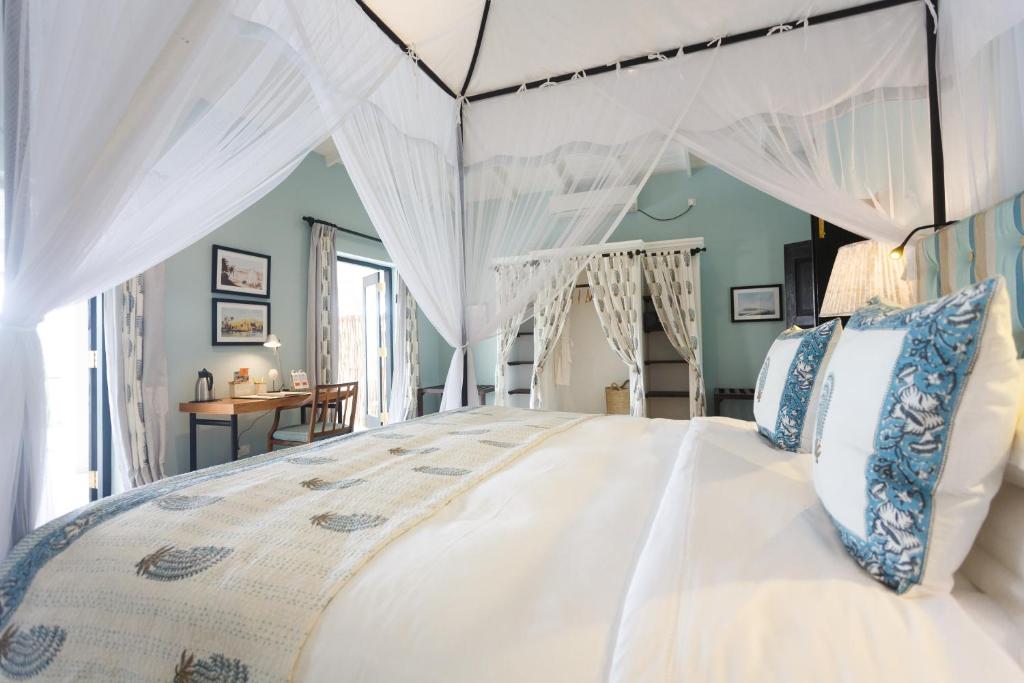 a bedroom with a white bed with a canopy at Kahanda Kanda in Koggala