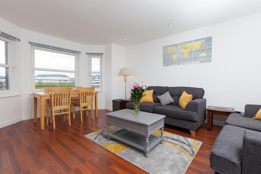 een woonkamer met een bank en een tafel bij Super Prime Duloch - Dunfermline - 2 Bed Executive Apartment in Dunfermline