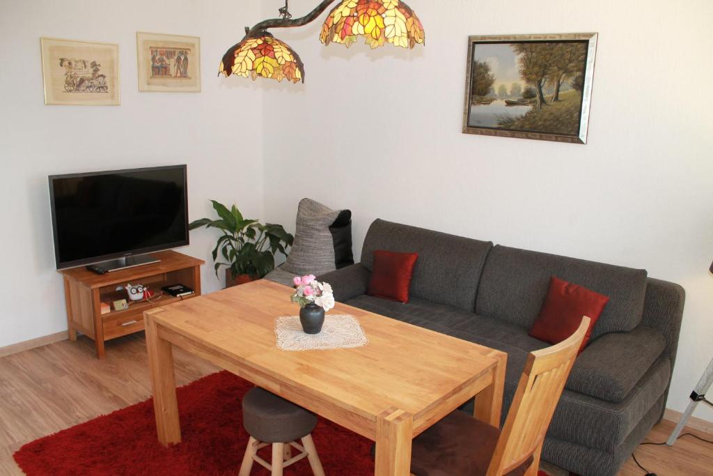 een woonkamer met een bank en een tafel bij Ferienwohnung-LOGA in Leer