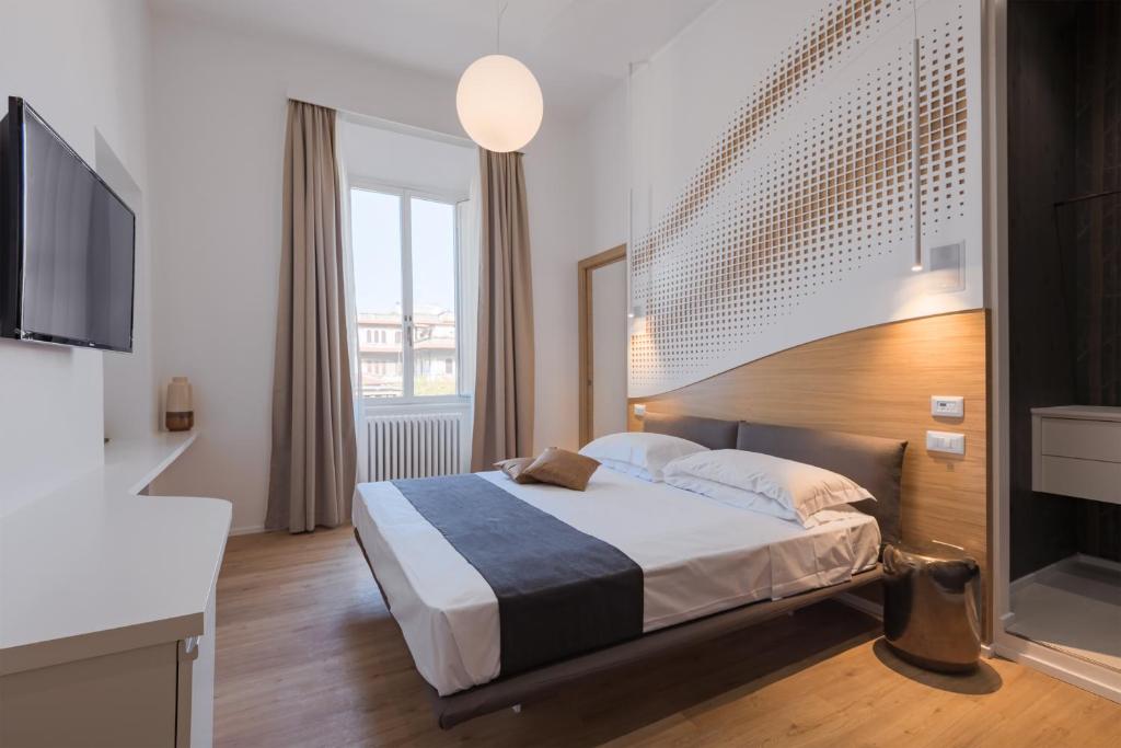 um quarto com uma cama e uma televisão de ecrã plano em NUMA ROMA GuestHouse em Roma