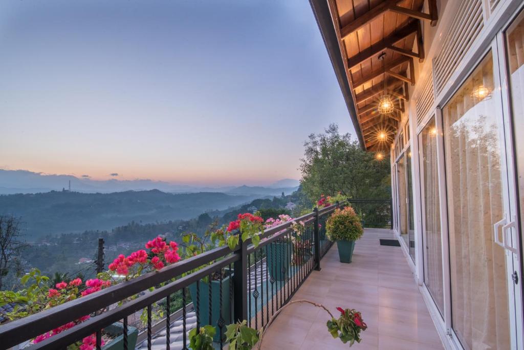 a balcony with pink flowers and a view at Beauty Hills in Kandy