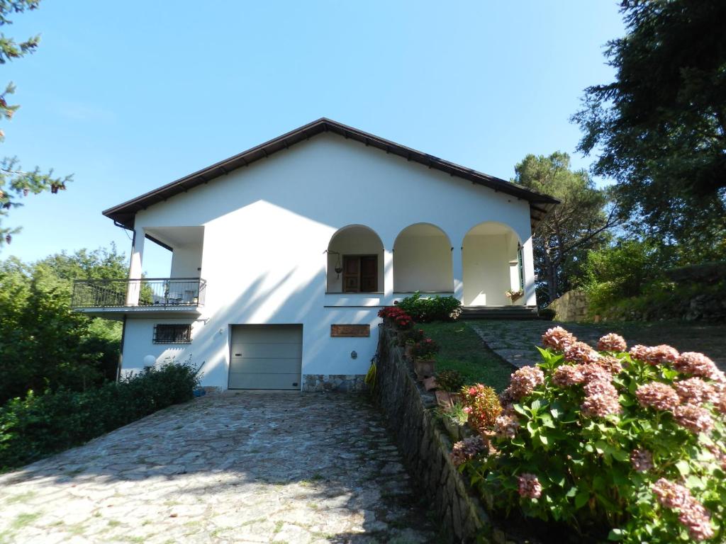 uma casa branca com uma entrada e flores em Casa del Sole, Villa indipendente isolata in area verde perfetta smart-working em Riccò del Golfo di Spezia