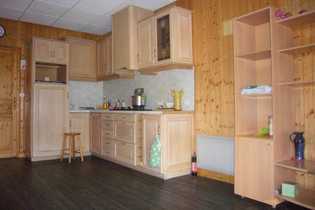 拉吉奧爾的住宿－les cimes le bouyssou，厨房铺有木地板,配有木制橱柜。