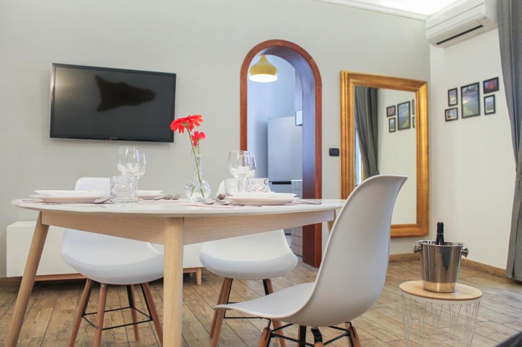a dining room with a table and white chairs at Il Magnifico Apartment in Catania