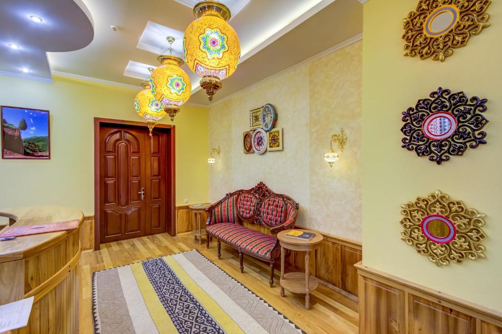 a living room with a couch and decorations on the wall at Navat Hotel in Bishkek