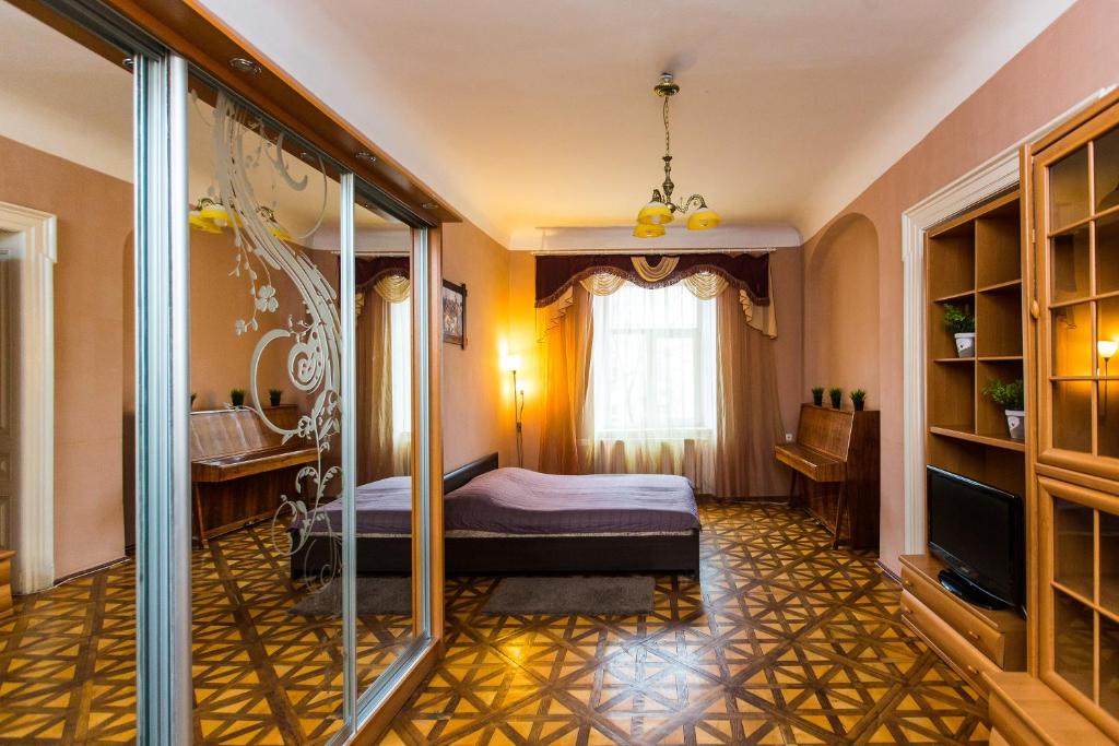 a bedroom with a bed and a television in a room at Apartments on Rynok Square in Lviv