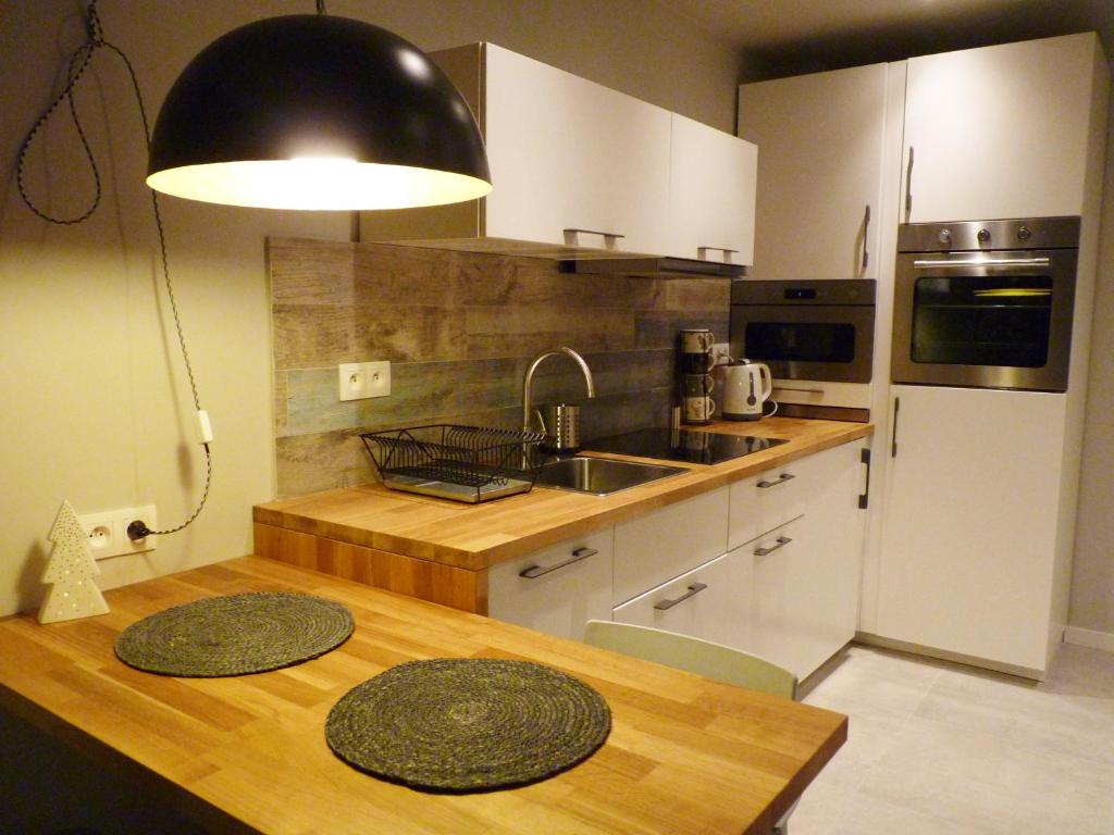 a kitchen with a table and a sink and a refrigerator at Apartament z liskiem in Szczyrk