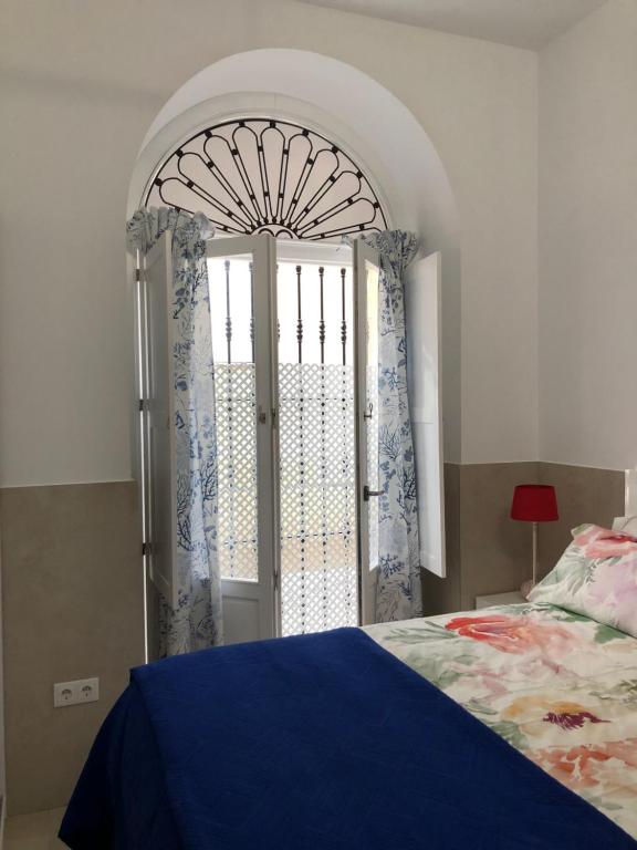 1 dormitorio con 1 cama y puerta abierta en Jano PuertaTierra en Cádiz