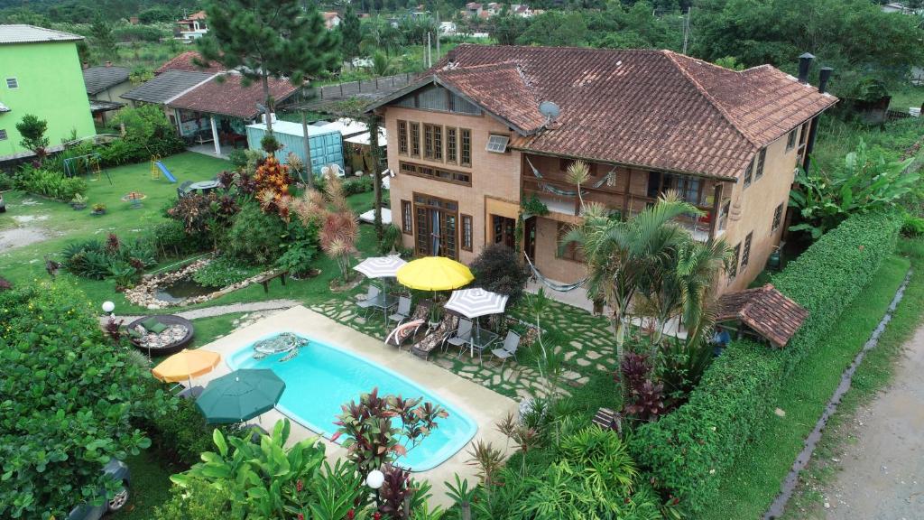 uma vista aérea de uma casa com piscina em EccO Capricornio em Caraguatatuba