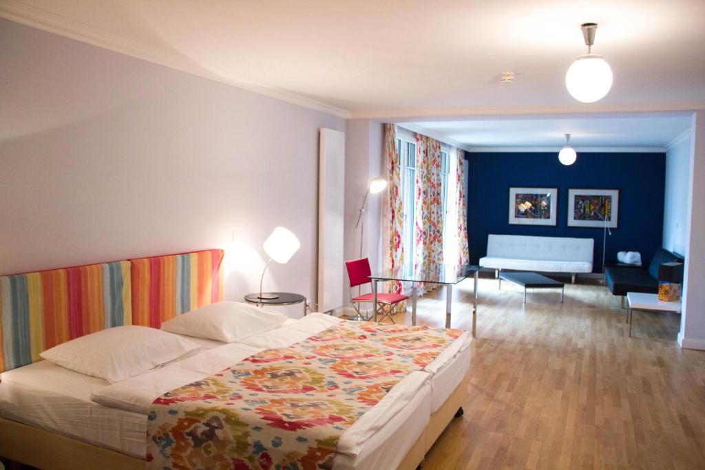 فندق داس في ميونيخ في ميونخ: غرفة نوم مع سرير وغرفة معيشة