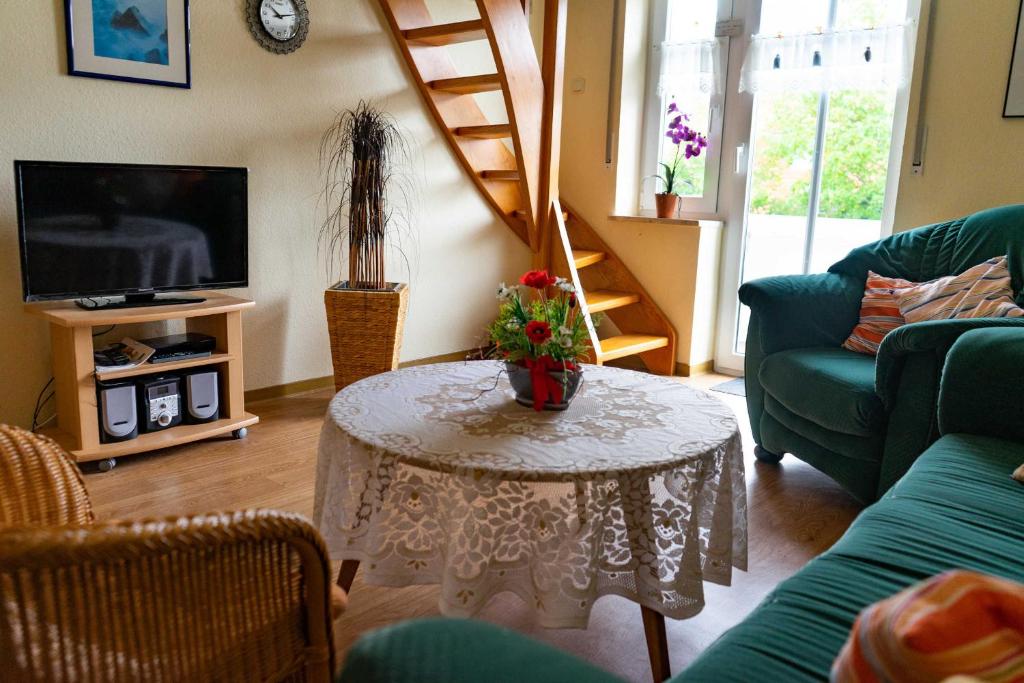 een woonkamer met een tafel en een televisie bij Ferienwohnung Janto in Hooksiel