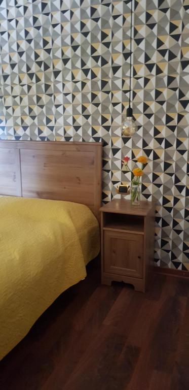 1 dormitorio con cama amarilla y mesa auxiliar en B&B del Lago, en Ispra