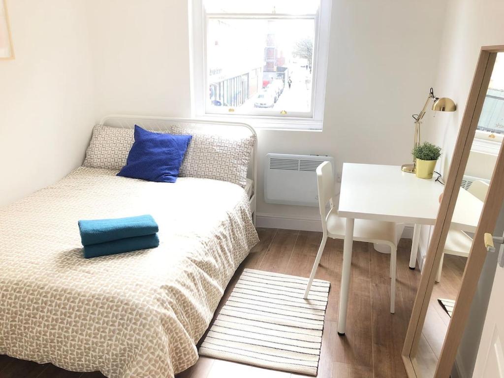 a small bedroom with a bed and a table at GRANBY APARTMENTS F-1 in Leicester