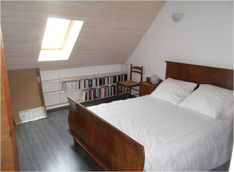 a bedroom with a large bed and a book shelf at Maison de vacances in Malbouzon