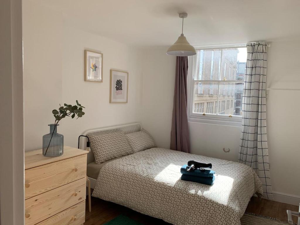 a bedroom with a bed and a dresser and a window at GRANBY APARTMENTS F-2 in Leicester