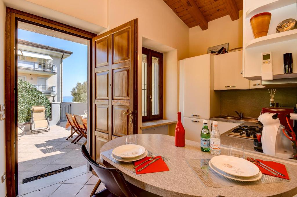 a kitchen with a table and a kitchen with a patio at Catullo Apartments Sirmione in Sirmione