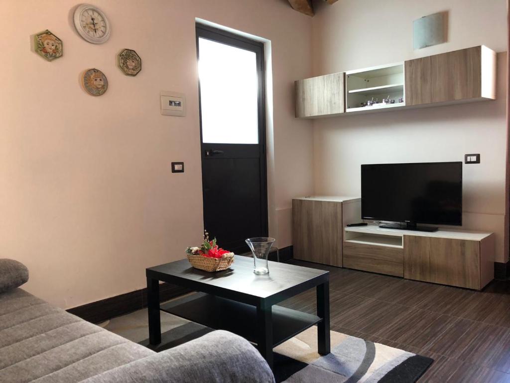 a living room with a couch and a tv and a table at Green Orange Catania Ognina in Catania