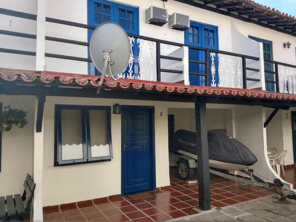 a house with a blue door and a balcony at RESIDENCIA DOS LEAIS in Arraial do Cabo