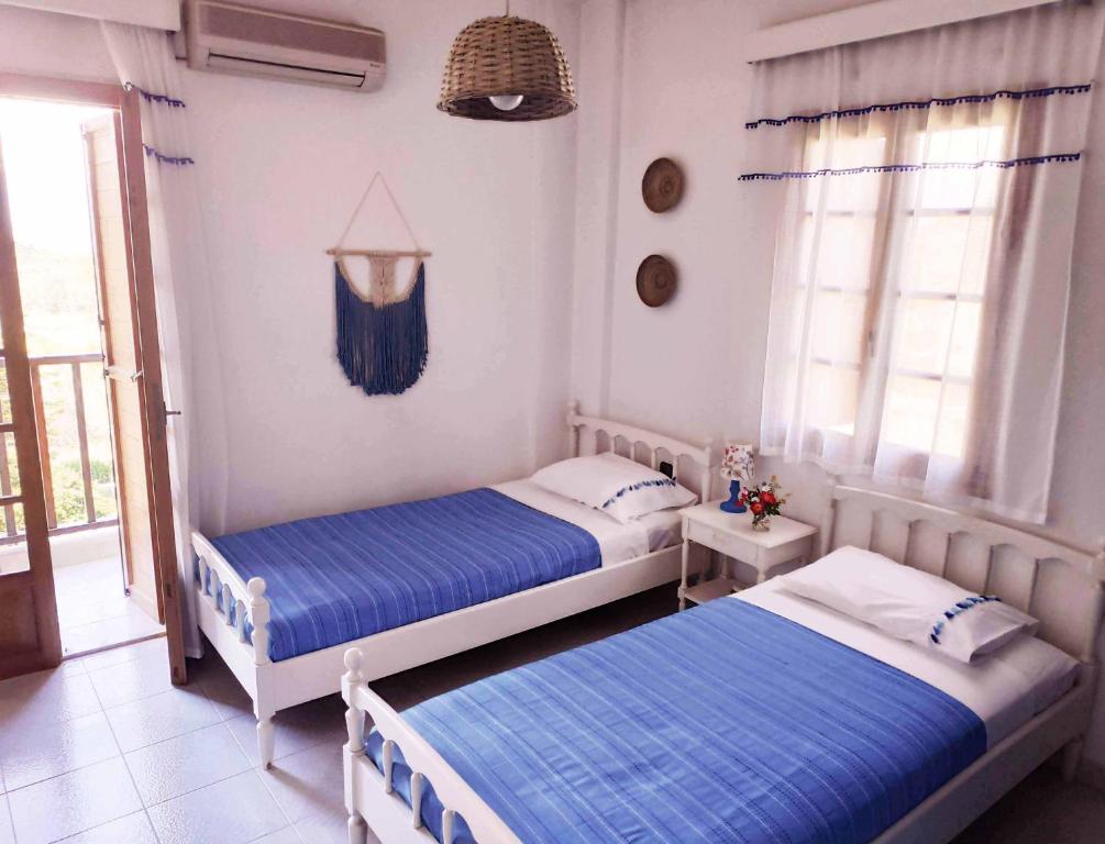 two beds in a room with blue sheets at Koel Country House in Áno Almirí