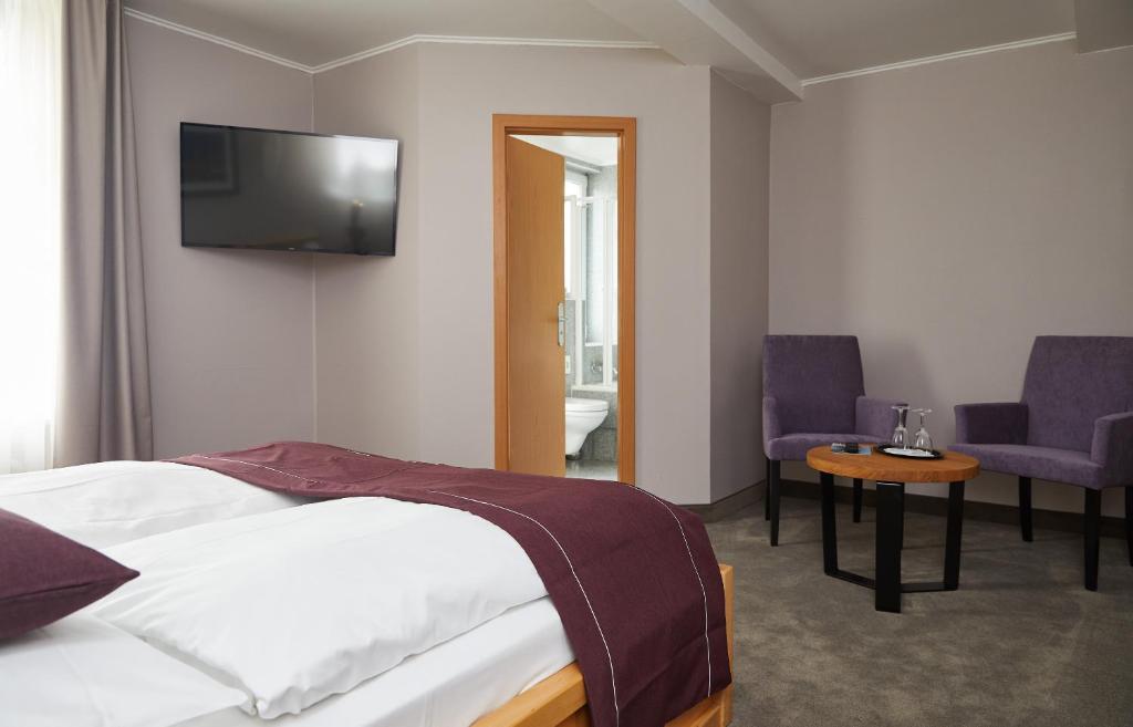 a hotel room with a bed and a tv on the wall at Hotel Hafentor in Hamburg