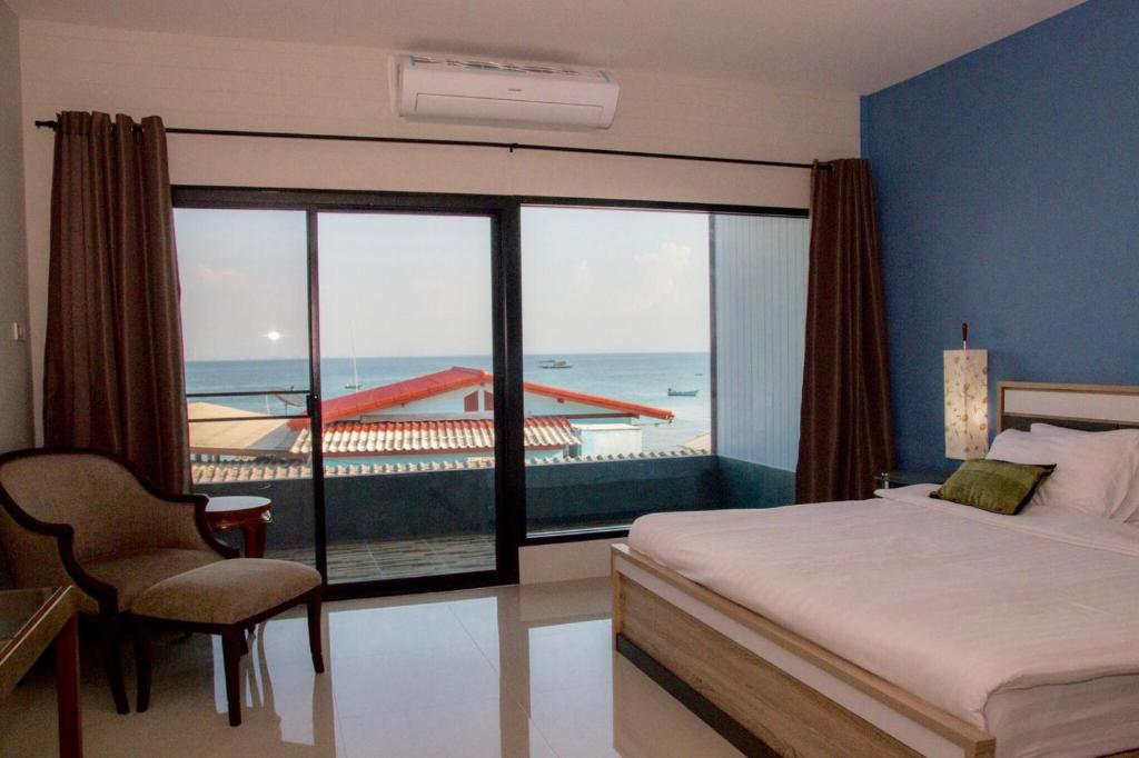 a bedroom with a bed and a view of the ocean at Chill Days @ Koh Larn in Ko Larn