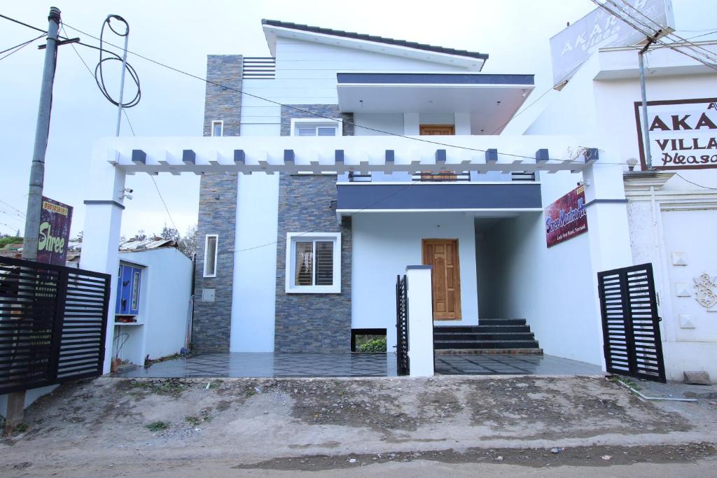 una casa blanca con una puerta delante de ella en Shree Mantra Homestay, en Yercaud