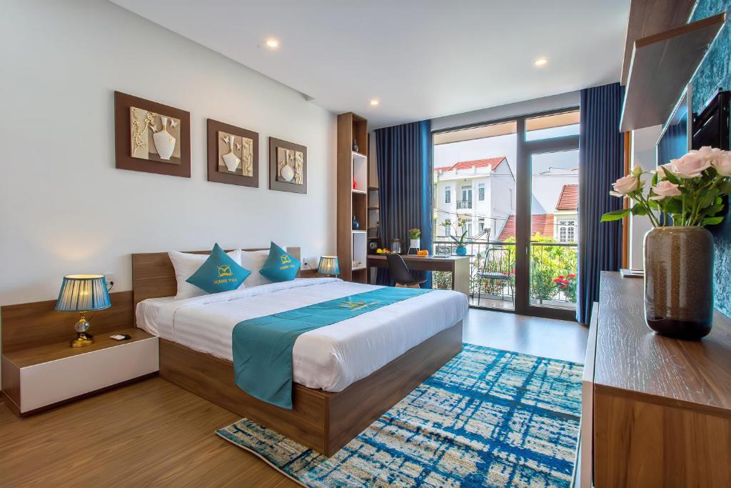 - une chambre avec un grand lit et un balcon dans l'établissement Square Villa Hoi An, à Hội An
