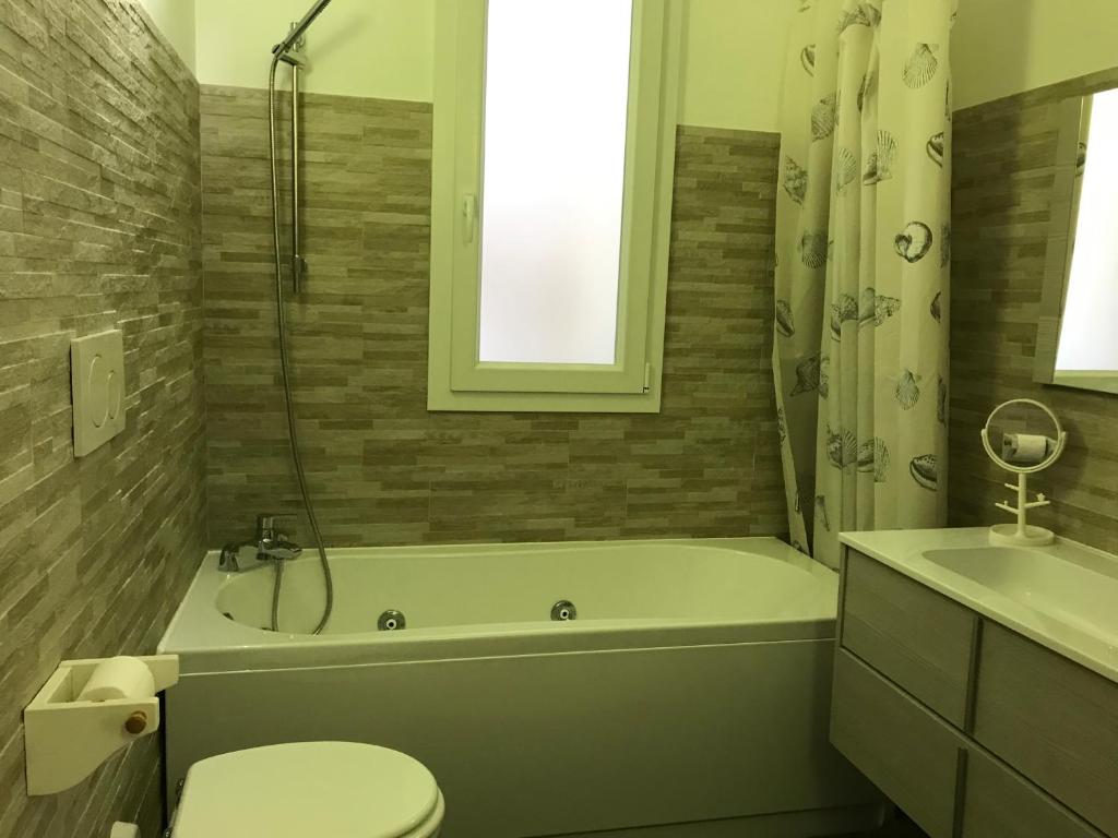 a bathroom with a tub and a toilet and a sink at Casa del sasso in Bergeggi