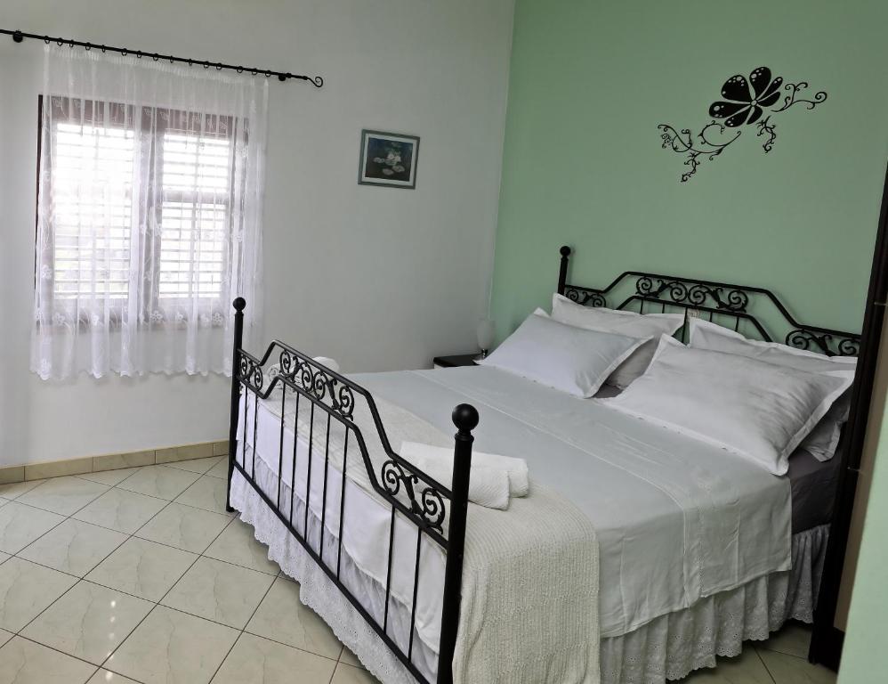 - une chambre avec un lit doté de draps blancs et une fenêtre dans l'établissement Apartments IDA Sucuraj, à Sućuraj