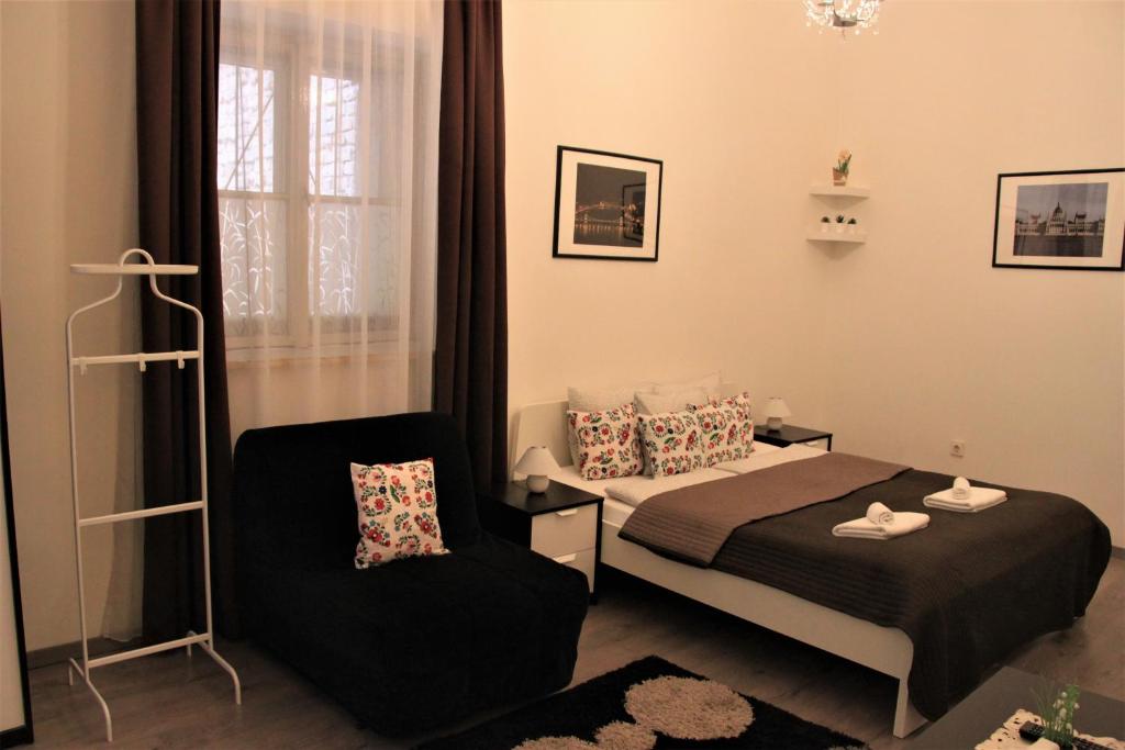 ブダペストにあるDuna Szecsi Apartmanのベッドルーム1室(ベッド1台、椅子付)