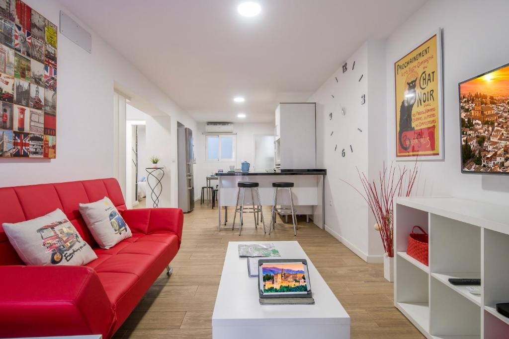 sala de estar con sofá rojo y mesa en Apartamento San Isidro, OZONO, en Granada