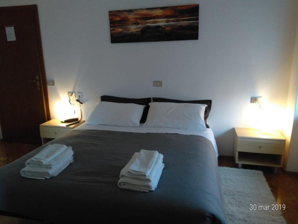 - une chambre avec un lit et 2 serviettes dans l'établissement Albergo San Giorgio, à Baselga di Pinè