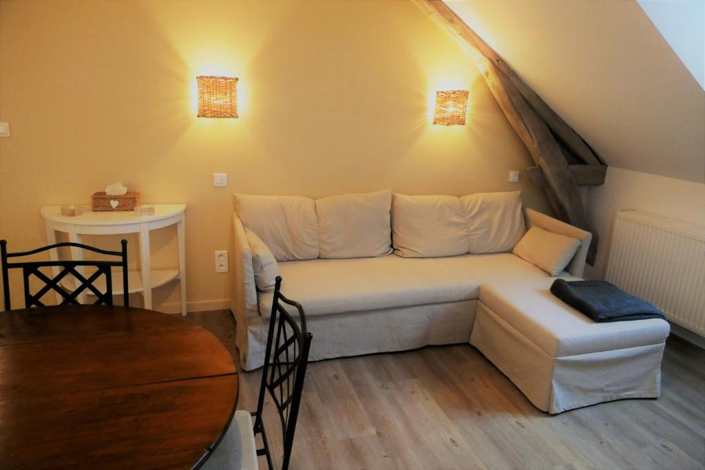 a living room with a couch and a table at La maison Virginie logements de 1 à 5 pers chaleureux centre, parking, linge, wifi, proximité lac canal piscine in Montargis