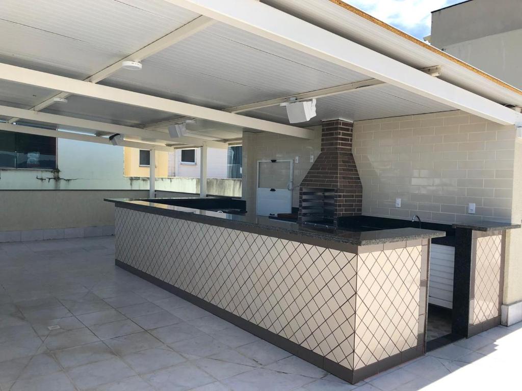 a large outdoor kitchen with a counter in a building at Pousada Reserva do Sahy in Mangaratiba