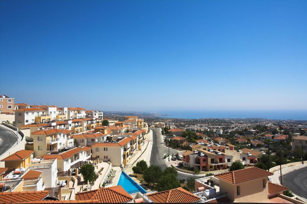 an aerial view of a town with buildings and the ocean at Club Coral View Resort in Peyia