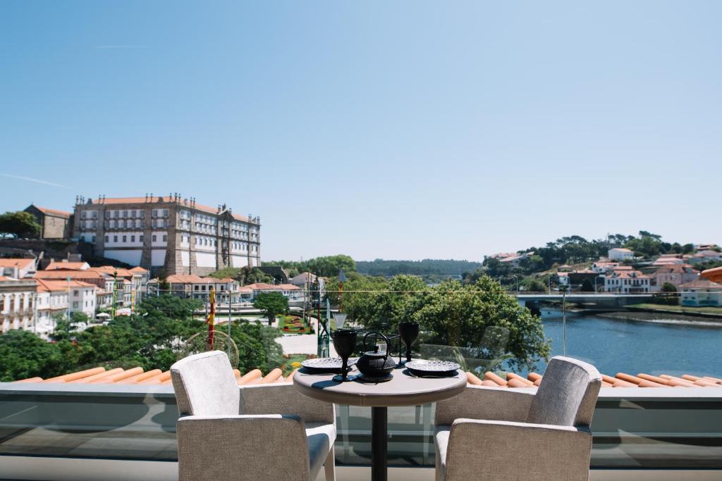 a dining room table with a balcony overlooking the ocean at Casa do Rio charm suites in Vila do Conde