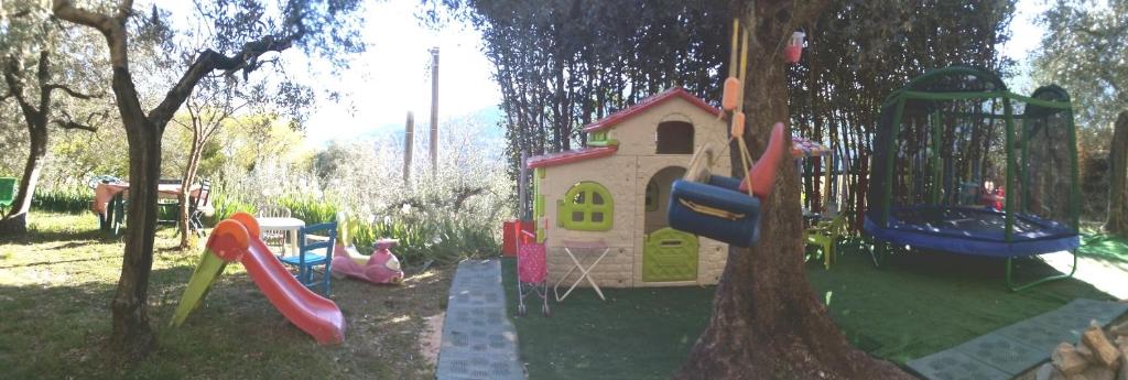 un parco giochi per bambini con un set di giochi e un albero di Guesthouse Runcini a Ferentillo