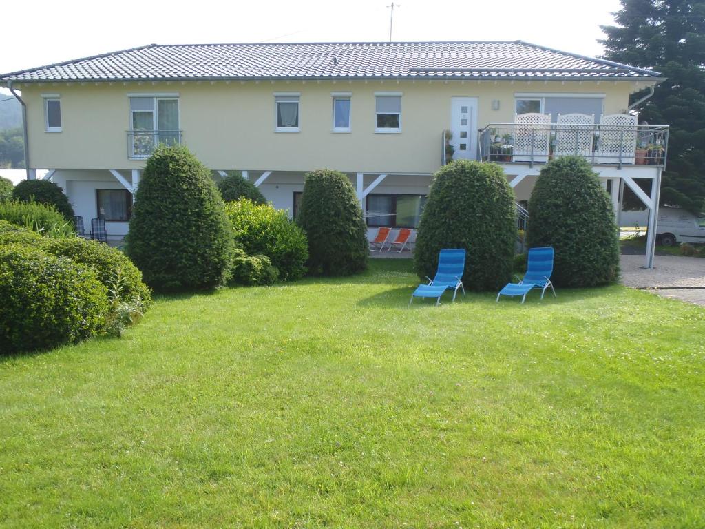 zwei blaue Stühle im Hof eines Hauses in der Unterkunft Carpe Diem in Kelberg